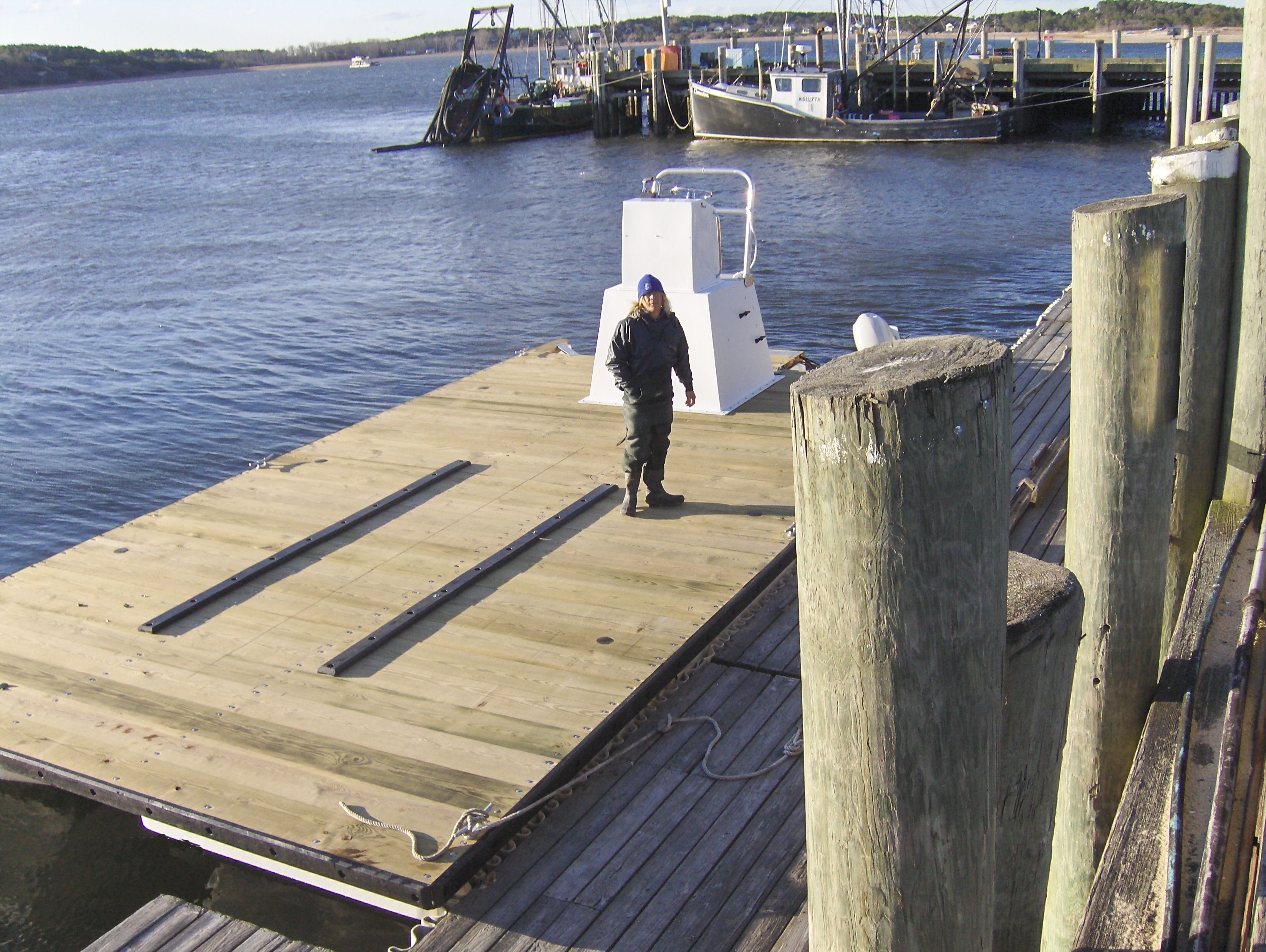 Deputy shellfish warden standing on barge in water